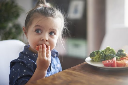 Mergaitė valgo daržoves (nuotr. Fotolia.com)
