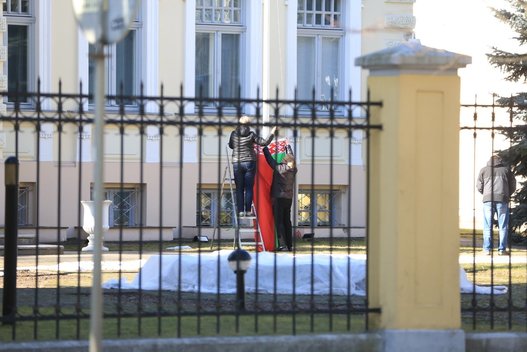 Baltarusijos ambasadoje Vilniuje darbuotojai kabina naują vėliavą (nuotr. Broniaus Jablonsko)