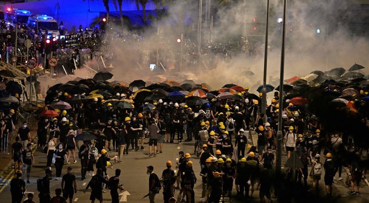 Riaušės Honkonge: ašarinių dujų debesys privertė sprukti protestuotojus – daugiausiai kaukėtus jaunuolius. (nuotr. SCANPIX)