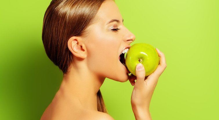Moteris valgo obuolį (nuotr. 123rf.com)