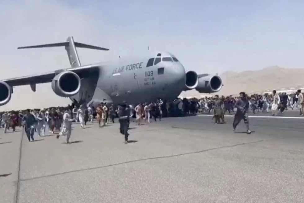 Šokiruojantys vaizdai iš Kabulo oro uosto: afganai kabinasi į bepakylančius lėktuvus (nuotr. stop kadras)